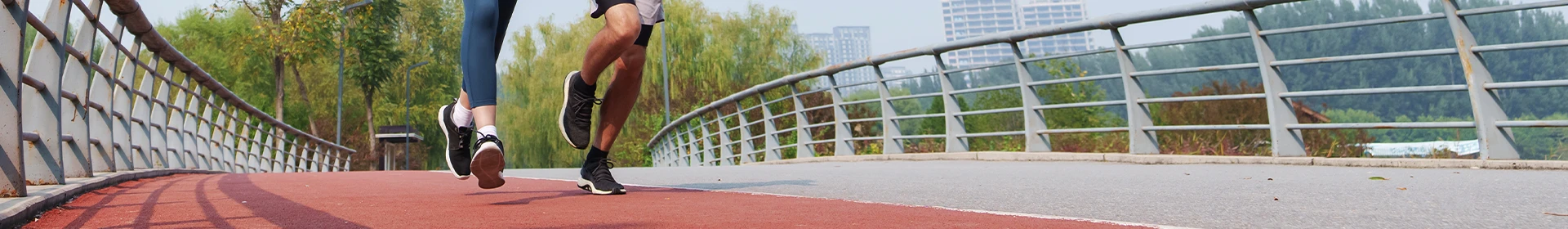 A couple running on an outdoor bridge