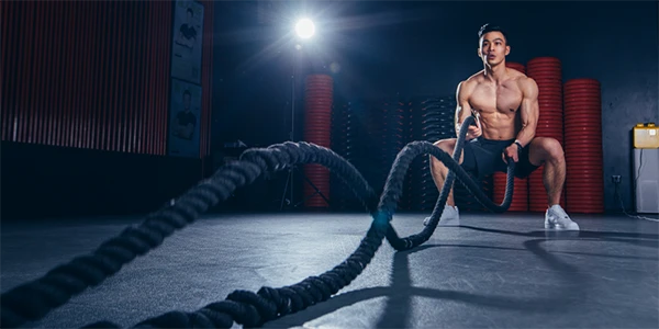 Un hombre está balanceando una cuerda en un gimnasio.