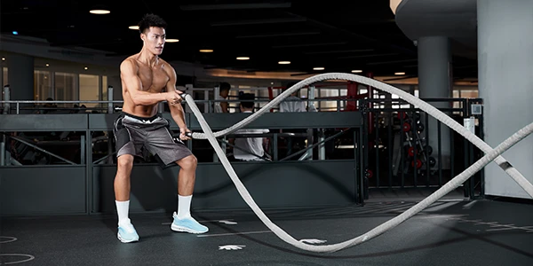Un homme fort balance ses bras pour un exercice ciblé