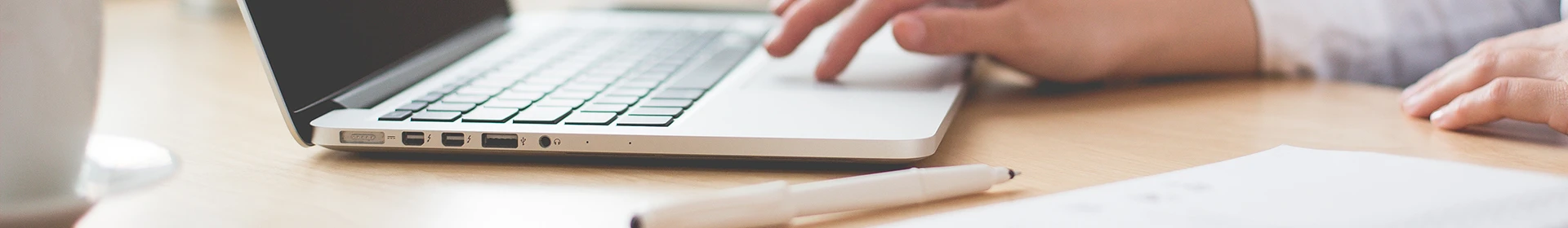 Um funcionário está usando o computador em cima da mesa.