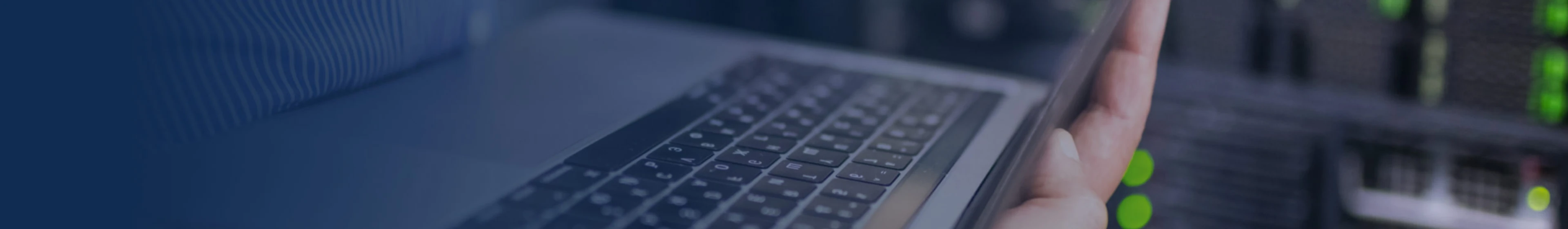 Tem uma mão segurando um laptop.