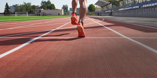 Un hombre está corriendo en la pista de atletismo.